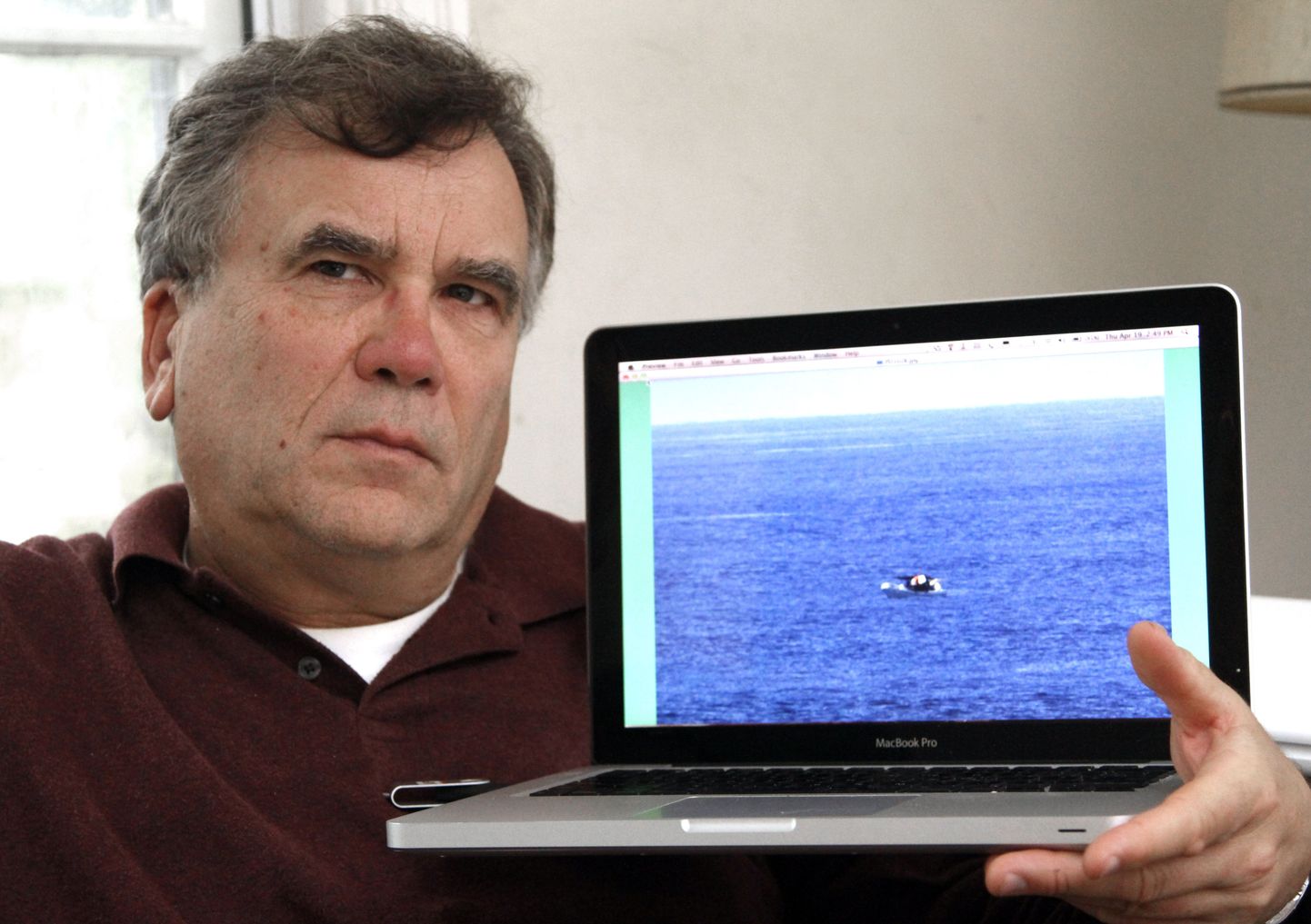 Jeff Gilligan näitab oma sülearvutis olevat fotot kalalaevast, mille ta reisijana tegi kruiisilaeva Star Princess pardalt.