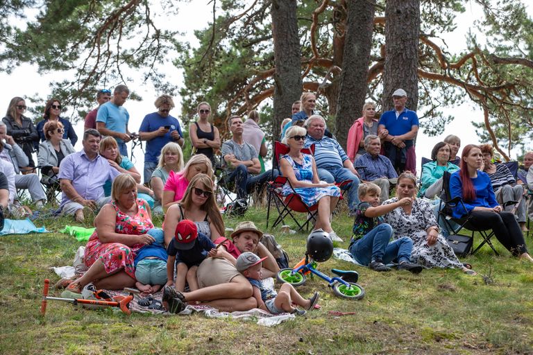 Концерт под прибрежными соснами в Каукси публика слушала сидя на своих походных стульях и одеялах для пикника.