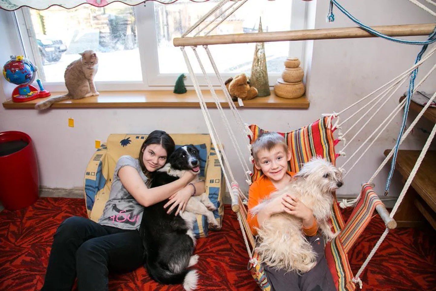 Suur sõbralik pere, kus lisaks emale-isale on kolm last, kaks kassi ja koera. Aknalaual istub kass Hoskan, Mari-Helen hoiab süles Põrra-Põrrat, Uku-Bert Pentut, pildilt on puudu peretütar Anni-Lii ja kass Koma.