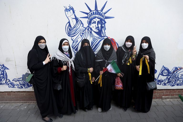Иранские женщины стоят перед стеной бывшего посольства США украшенного антиамериканскими фресками во время 42-й годовщины изгнания США из Ирана, Тегеран, 4 ноября 2021 года.