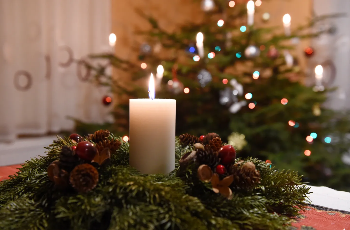 Adventes vainags un svētku eglīte Ziemassvētku vakarā.