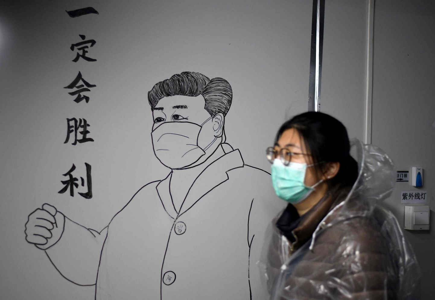 Näomaskis naine möödub Hiina presidendi Xi Jinpingi pildist, mis on joonistaud Hubei provintsis Leishenshani koroonaviiruse patsientidele ehitatud haigla seinale.