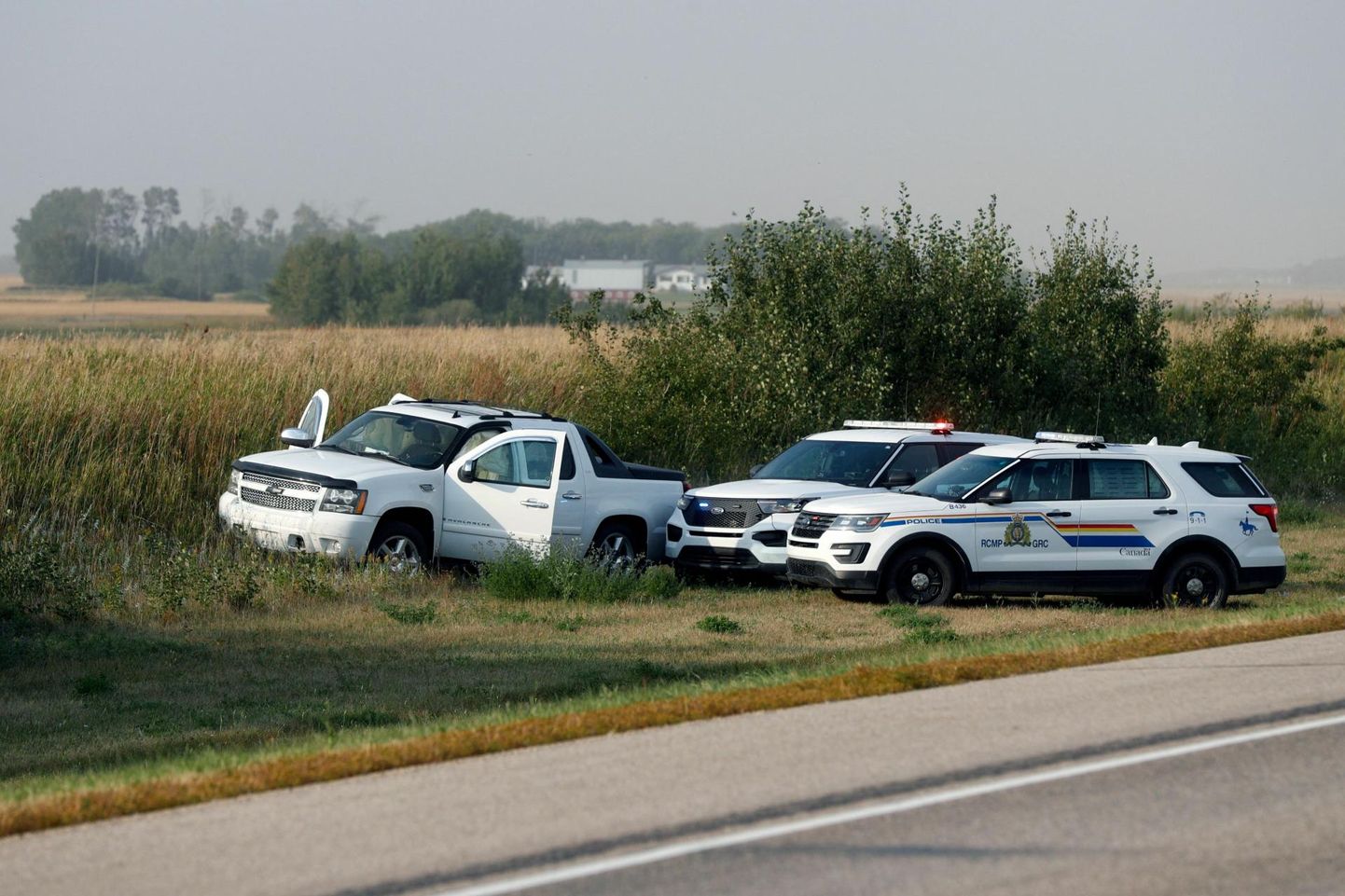 Kanada kuningliku ratsapolitsei sõidukid Myles Sandersoni varastatud auto kõrval sündmuskohal, kus mees lõpuks arreteeriti.