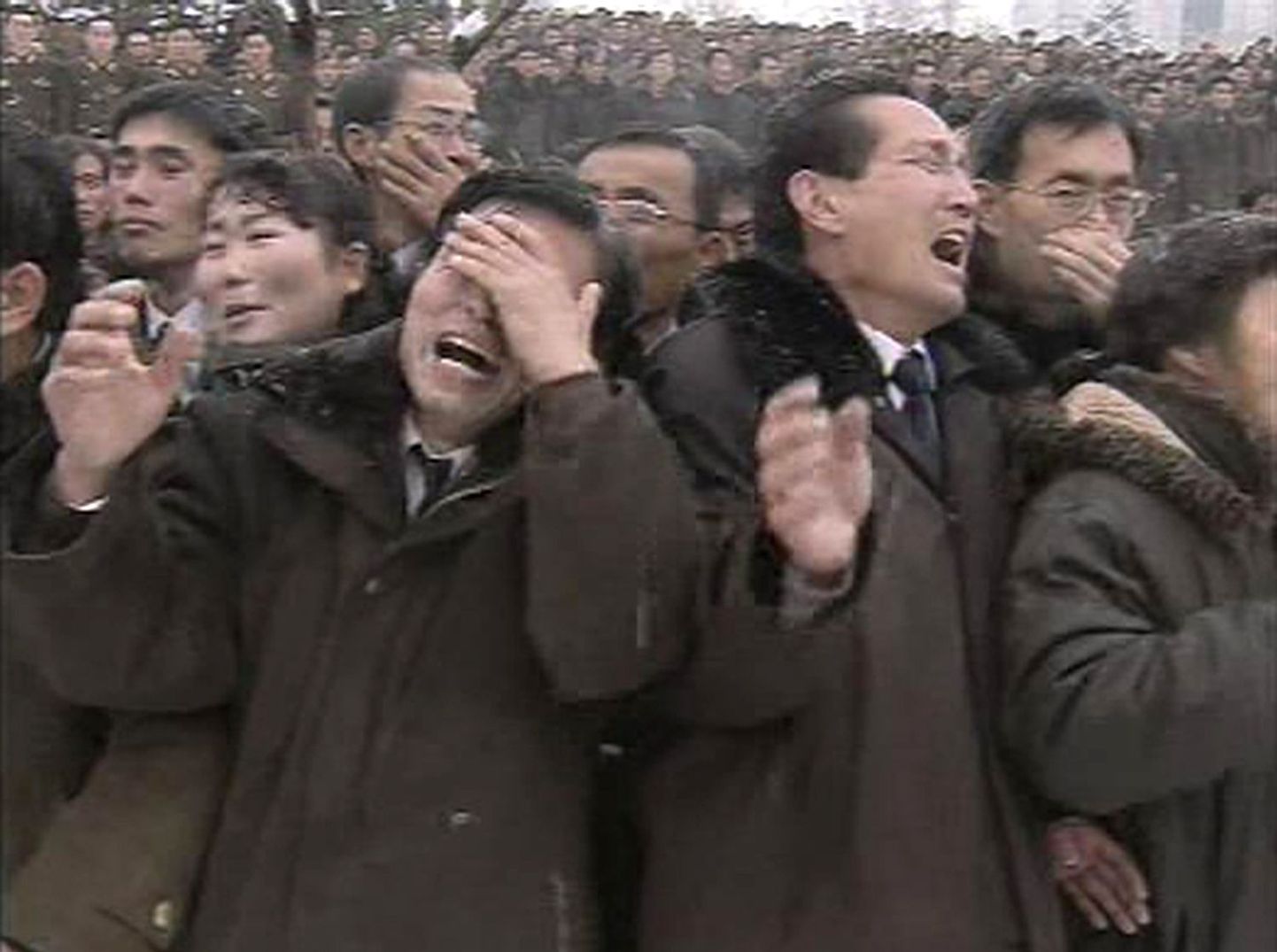 Nutvad põhjakorealased vaatavad eksdiktaatori Kim Jong-ili matuserongi möödumist.