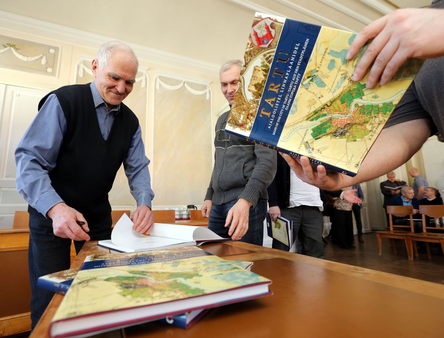 Kümned ajaloohuvilised tartlased piirasid eile kartograaf Tõnu Raidi, paludes autorilt vastilmunud raamatusse autogrammi.