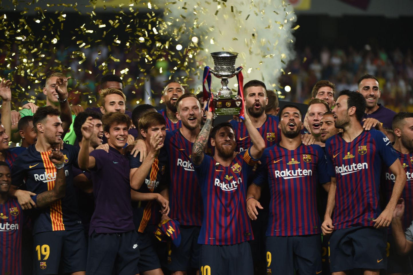 Barcelona's Argentinian forward Lionel Messi (C) carries the cup as they celebrate at the end of the Spanish Super Cup final between Sevilla FC and FC Barcelona at Ibn Batouta Stadium in the Moroccan city of Tangiers on August 12, 2018. - Barcelona defeated Sevilla 2-1 to win the Spanish Super Cup. (Photo by FADEL SENNA / AFP)