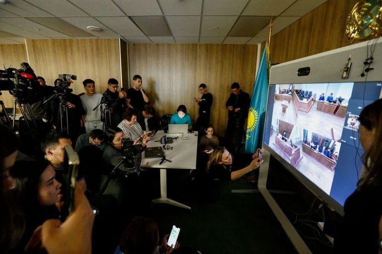 Журналисты смотрят прямую трансляцию во время предварительного слушания по делу Бишимбаева 11 марта 2024 года