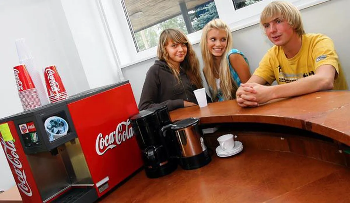 Jakobsoni gümnaasiumi õpilased (vasakult) Merilyn Tiit, Aliis Andersohn ja Rasmus Luhakooder istuvad Coca-Cola joogiautomaadi kõrval, kust möödunud nädalast voolab vaid vett.
