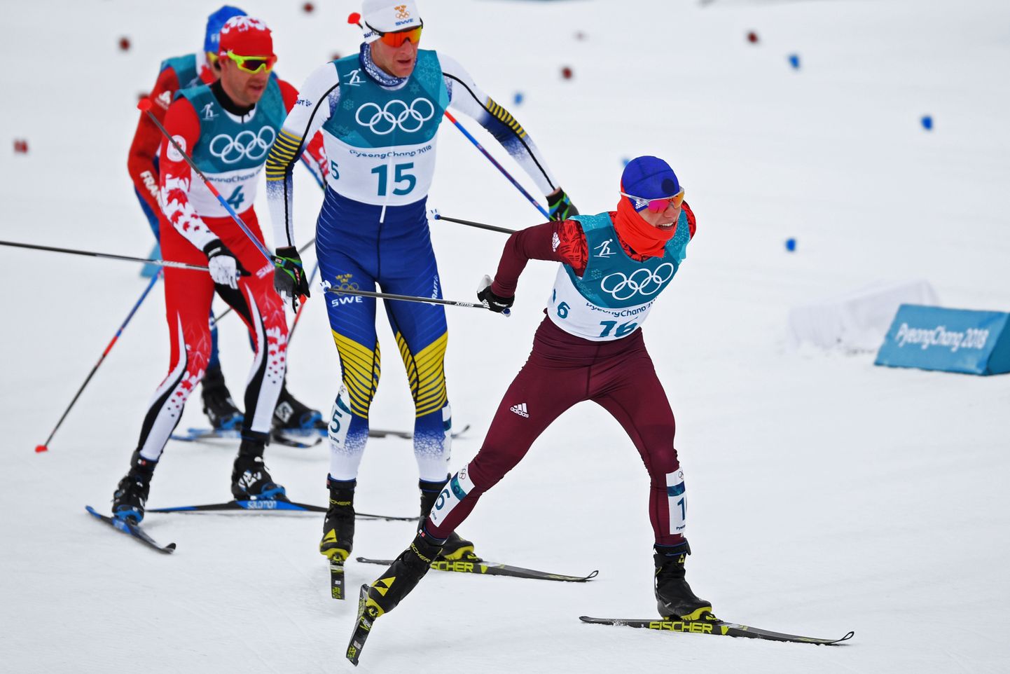 Россиянин Денис Спицов (номер 16) и Алекс Харви (номер 4) ведут борьбу на трассе Пхенчхана в лыжном скиатлоне