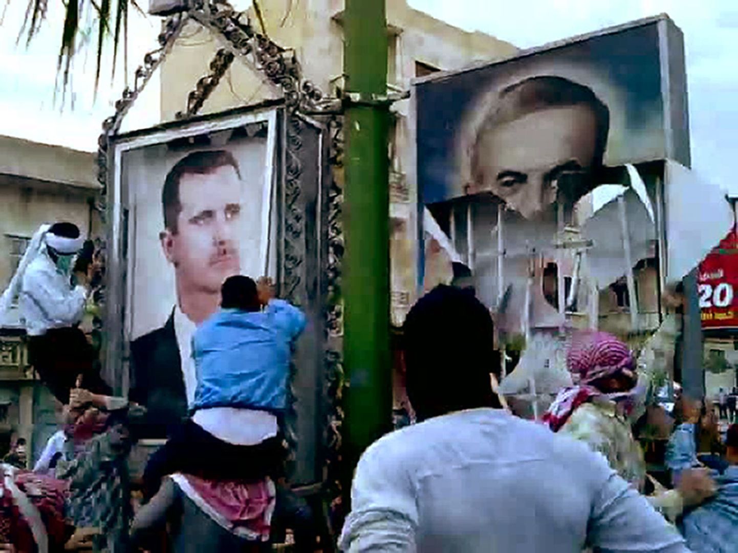 Süüria valitsusvastased protestijad 29. aprillil Hama linnas tirimas maha ekspresident Hafez al-Assadi (paremal) ja tema poja, praeguse presidendi Bashar al-Assadi fotot.