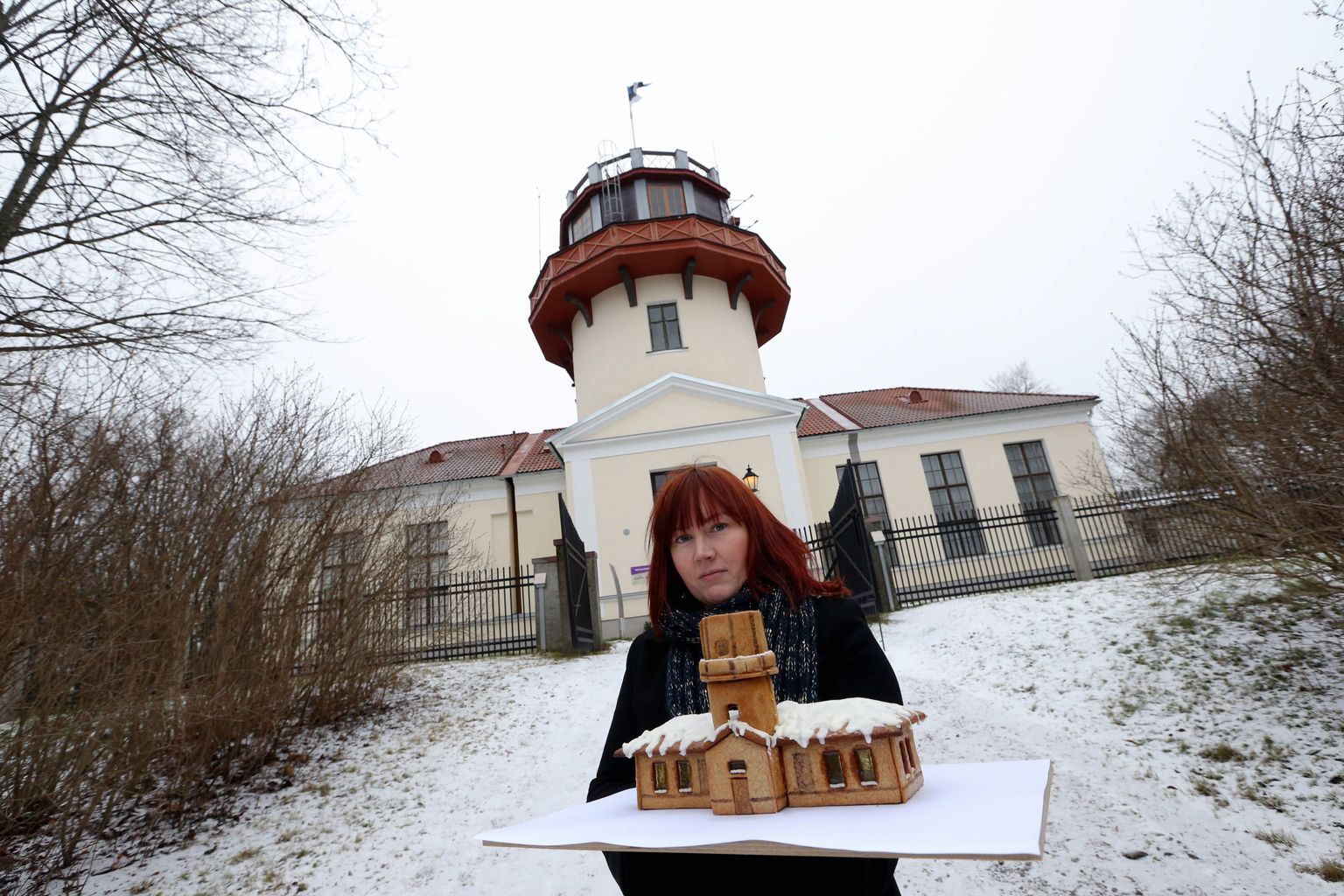 Pildil Tartu Postimehe piparkoogivõistluse võitja Maarja Roosi Tartu tähetorni kujutava piparkoogimajakesega tähetorni juures.