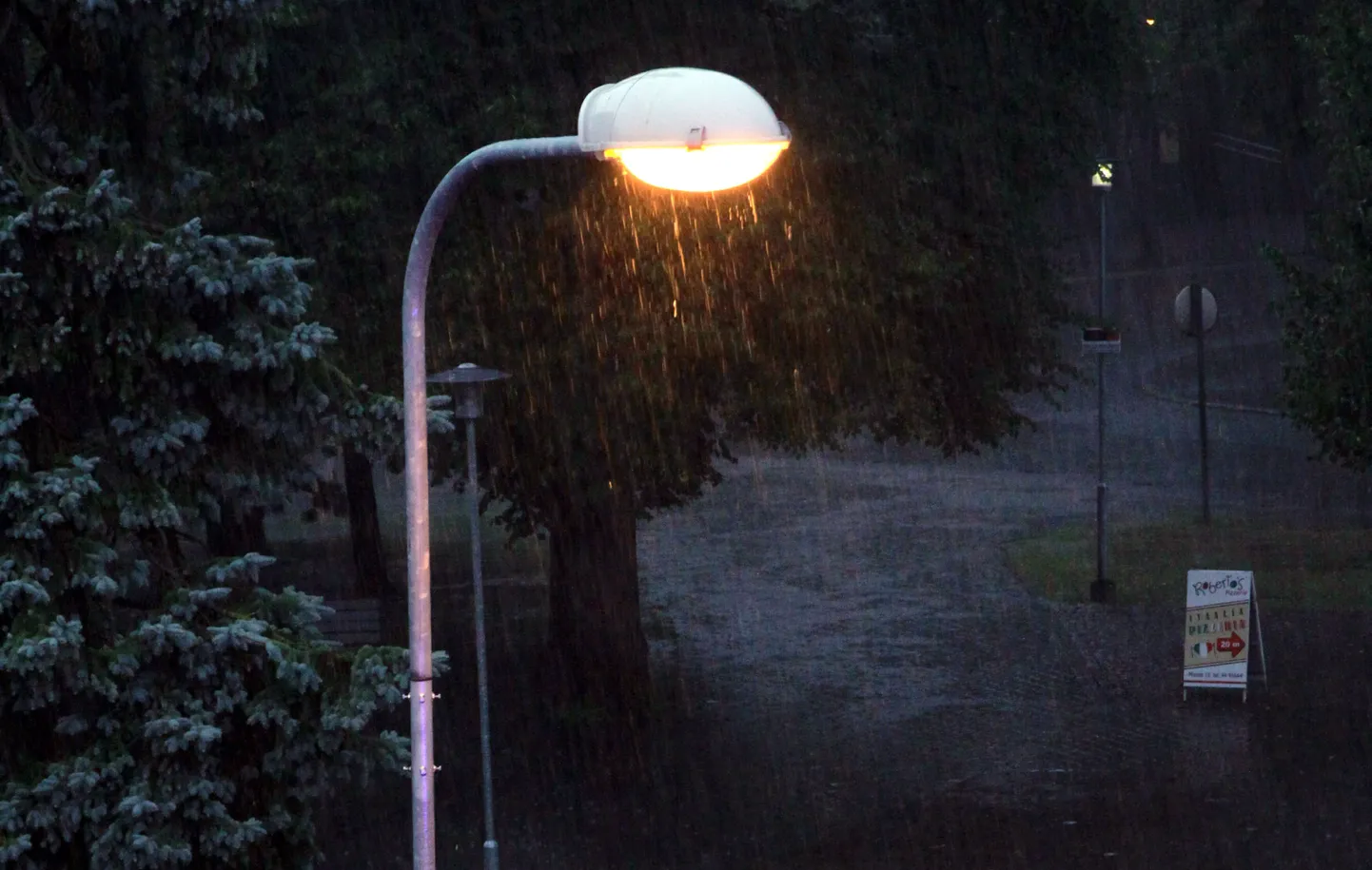 Üle Pärnu liikunud äikersepilv ja paduvihm muutsid ilma keset päeva nii pimedaks, et fotosilm pani tööle tänavavalgustuse.