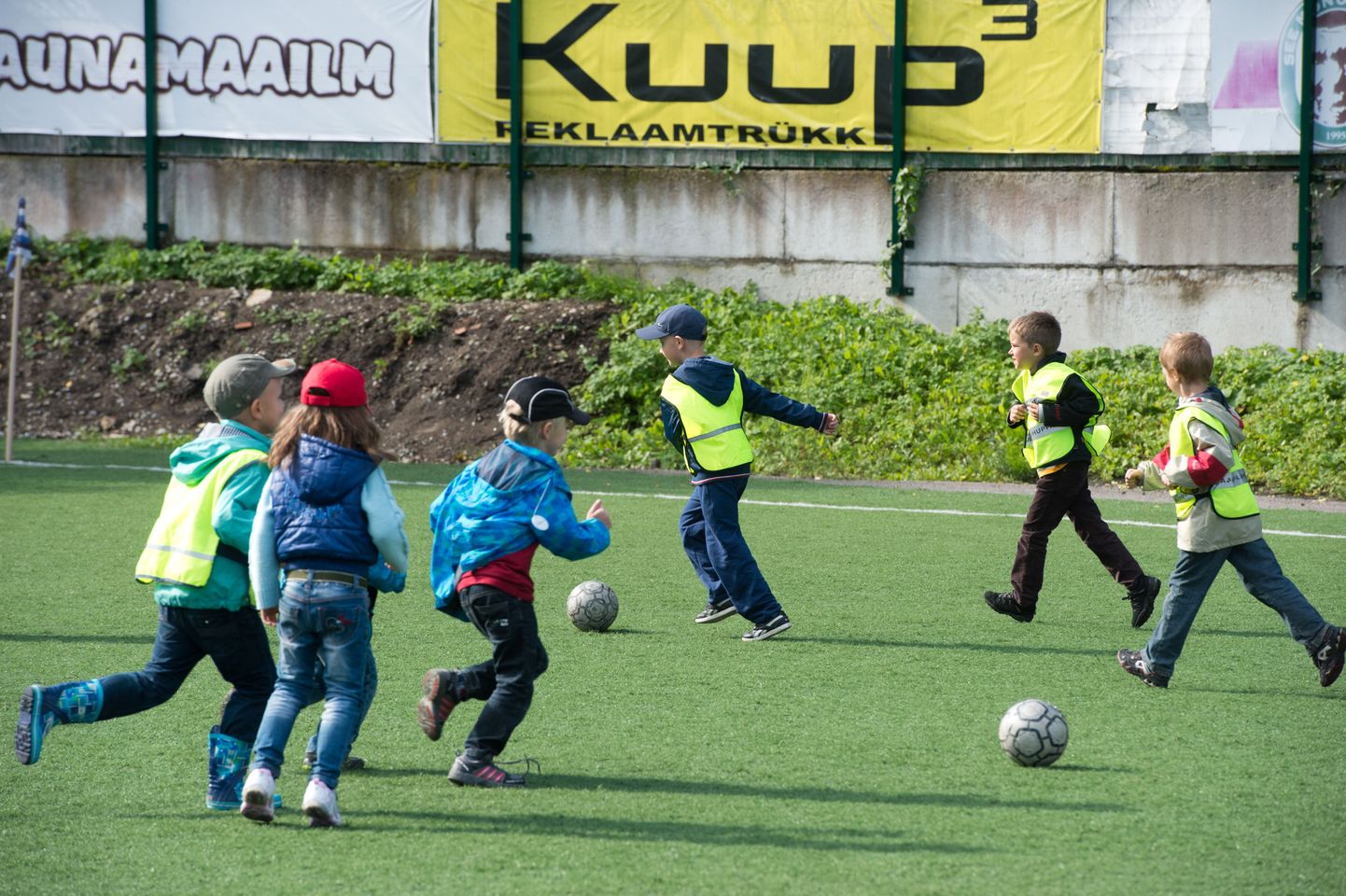 Lapsed staadionil jalgpalli mängimas.