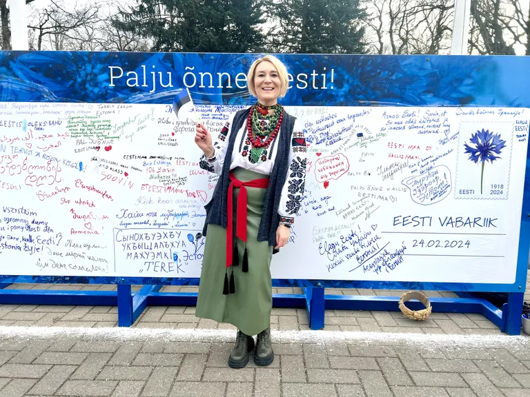 Инна Гордиенко на фоне специальной открытки к Дню независимости Эстонии.