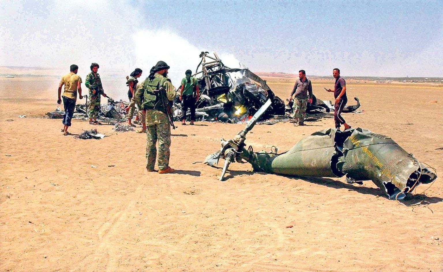 Боевики у обломков сбитого 1 августа на северо-востоке Сирии российского военно-транспортного вертолета.