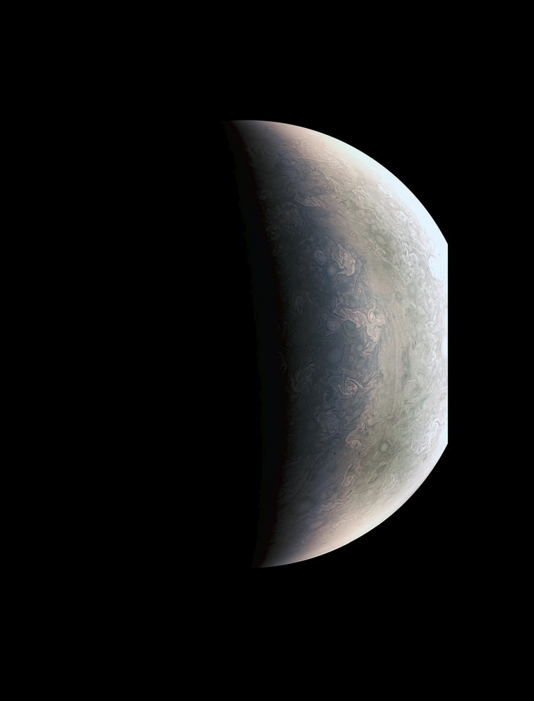Jupiteri põhjapoolus. Selle pildi tegemise hetkel oli Juno planeedi pinnast ligi 78 000 kilomeetri kõrgusel.Poolel teel vasakpoolse hallika ala ja parempoolse heledamates toonides ala vahel paistab lainjas piirjoon. Tegemist on nii-nimetatud Rossby lainega, mis tekib ida-lääne suunaliste jugavoolude tagajärjel.Polaaralal paistab rohkelt erinevaid atmosfäärinähtuseid, mille põhjal saavad teadlased teha järeldusi Jupiteri atmosfääri dünaamika kohta.