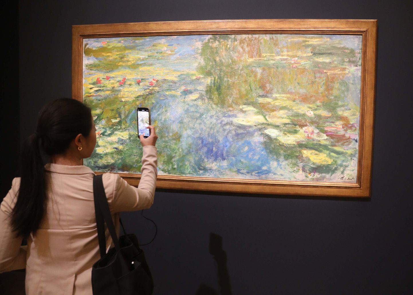 27. oktoobril 2023 naine pildistamas Claude Monet meistriteost «Le bassin aux nymphéas» (umbes 1917-1919)