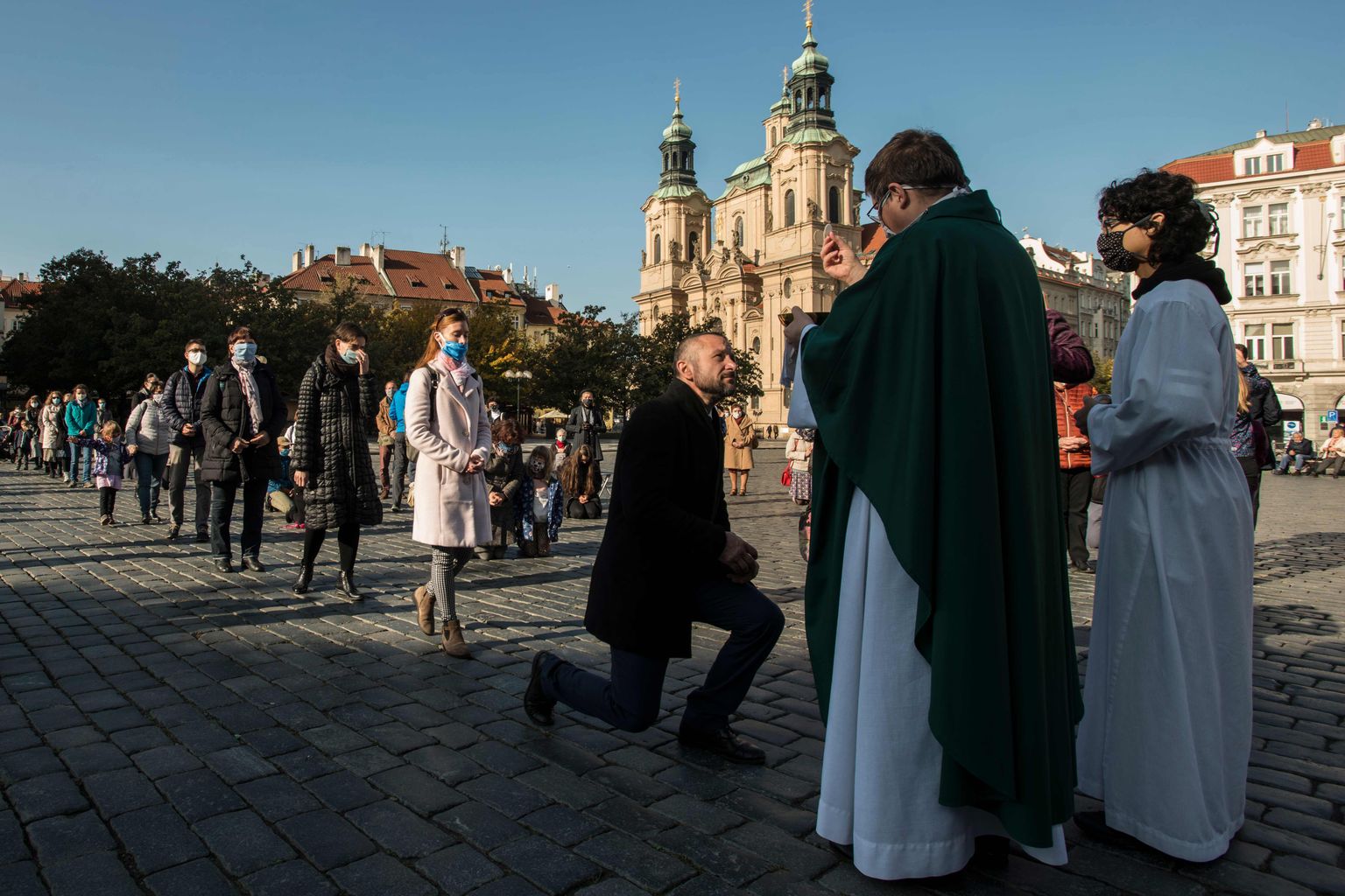Maskides inimesed pühapäevasel vabaõhumissal Praha vanalinna keskväljakul 25. oktoobril 2020.