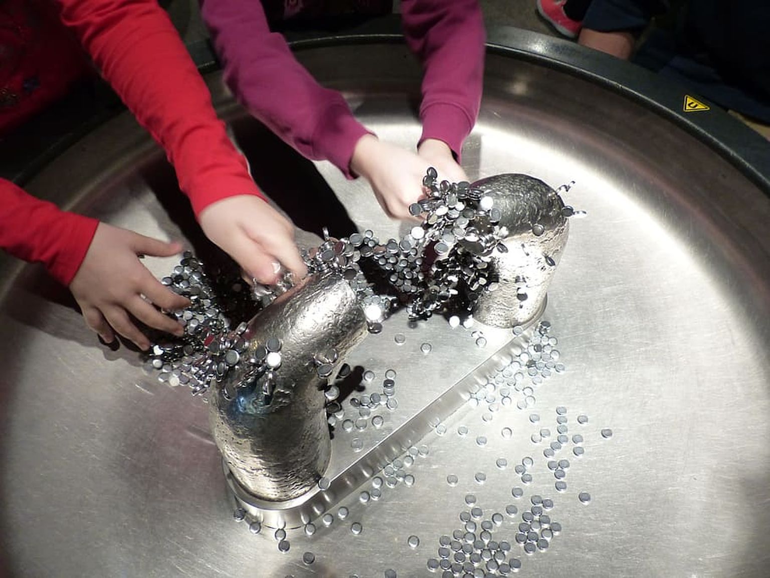 Lastele on tõeliseks magnetiks muuseumid, kus eksponaate saab katsuda ja nendega eksperimenteerida. Pildil katsetavadki lapsed seda, kuidas magneetuvad metallseibid «kleepuvad» püsimagneti poolustele.