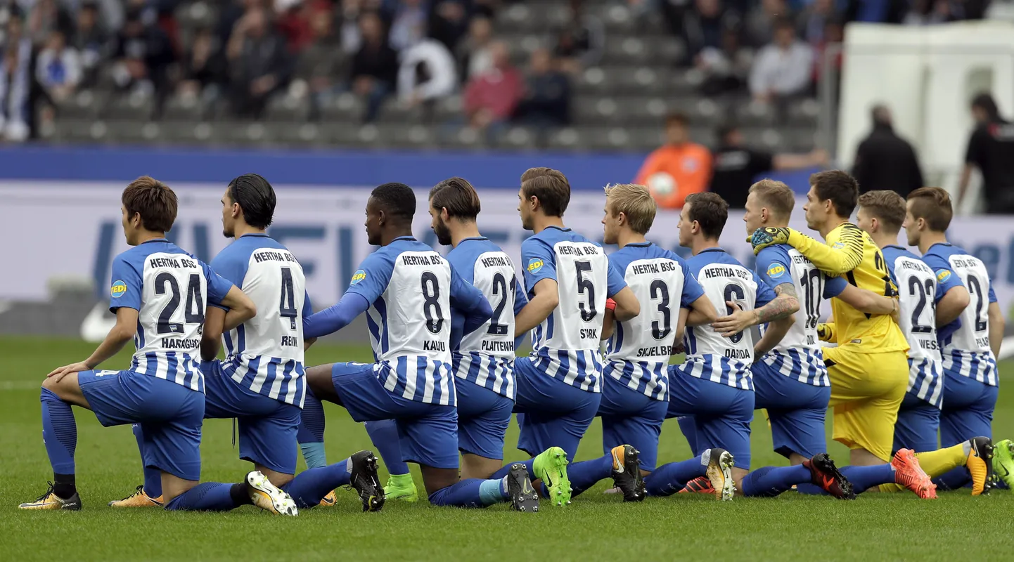 Players of Berlin kneel down prior to the German Bundesliga soccer match between Hertha BSC Berlin and FC Schalke 04 in Berlin, Germany, Saturday, Oct. 14, 2017. Hertha Berlin nodded to social struggles in the United States by kneeling before its Bundesliga game at home to Schalke on Saturday. Hertha