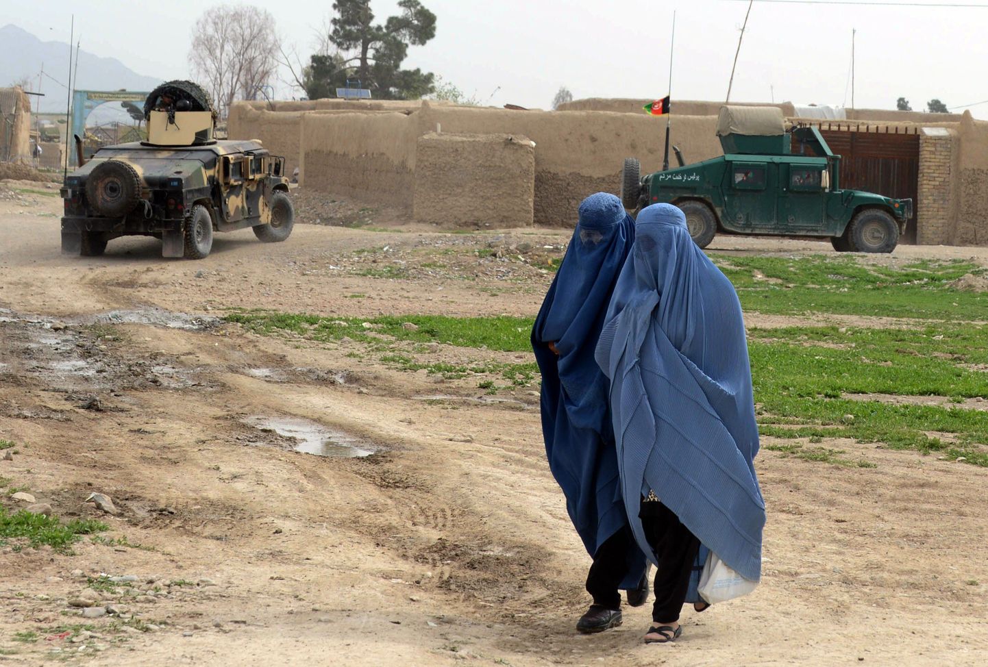 Afganistani naised Kandaharis presidendivalimisi turvavate julgeolekujõudude masinate läheduses.