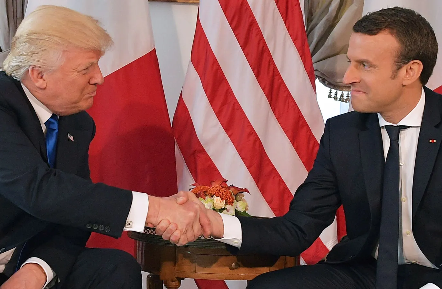USA president Donald Trump ja Prantsusmaa riigipea Emmanuel Macron teineteise kätt pigistamas.