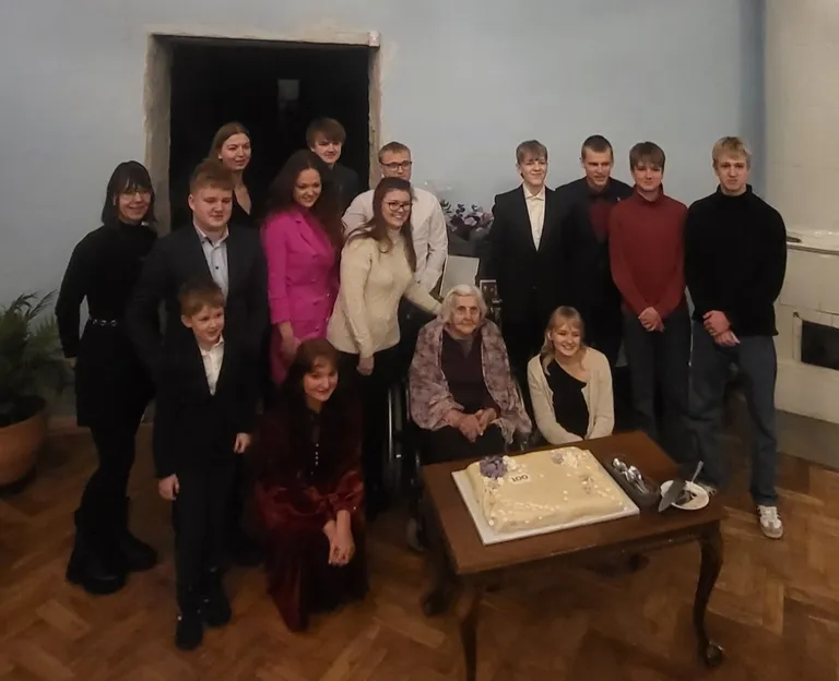 Erika lastelastega: vasakult Hanna-Marie Paate, Oliver Toovis, Linda Kübar, Kristiin-Heleen Toovis, Marten Toovis, Sten Reiter, Nicole Reiter, esimeses reas Theodor Toovis ja Katriina Aasmäe. Vanaemast paremal: Kaupo Rajamäe-Volmer, Kaur Rajamäe-Volmer, Fin Gustaf Aasmäe, Jon Kristof Aasmäe, vanaema kõrval Eva-Lota Rajamäe-Volmer.