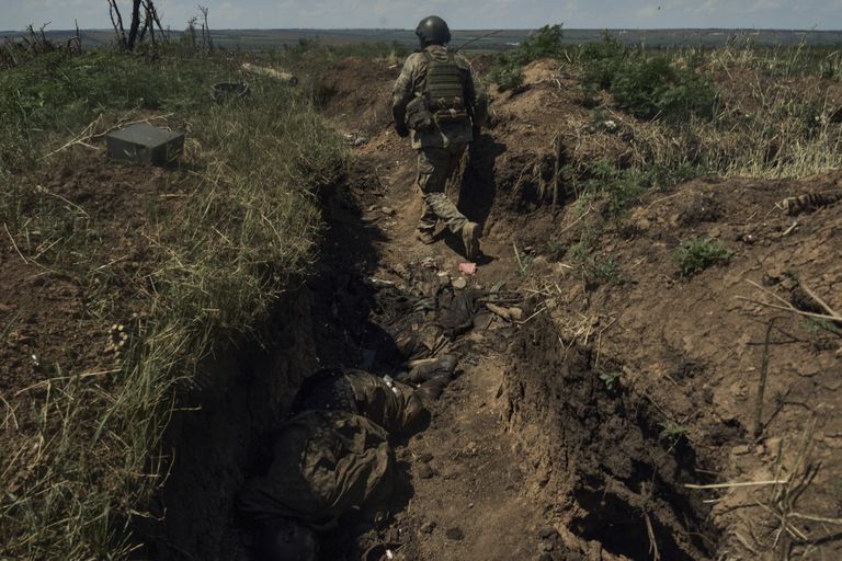 Ukraina sõdur möödub juulis 2023.a. vastaste laipadest kaevikus Bahmuti lähistel