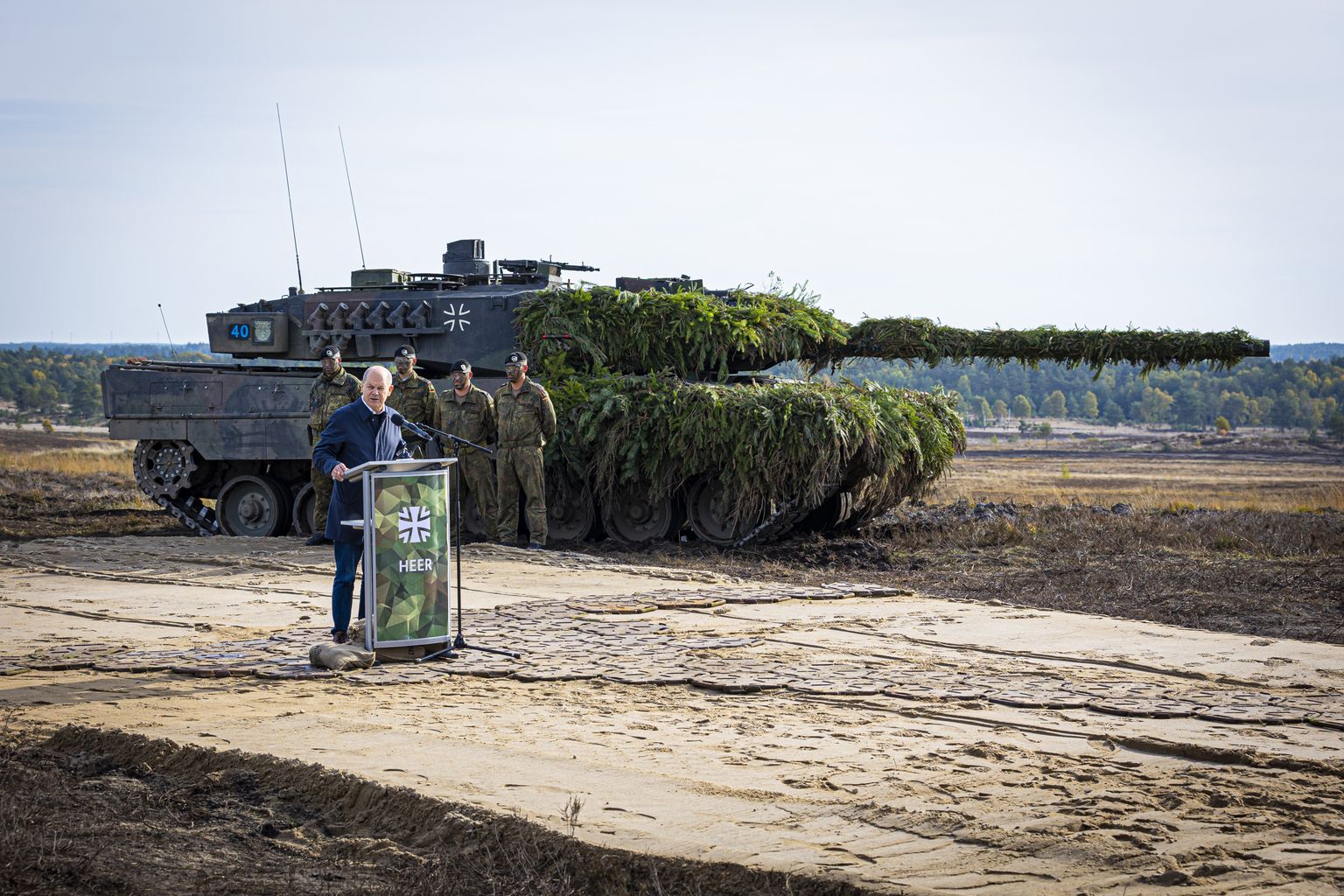 Saksa kantsler Olaf Scholz pidamas 17. oktoobril 2022 kõnet Saksa kaitseväe õppustel Ostenholzis. Taamal on näha osalise kamuflaažiga Leopard 2 tanki