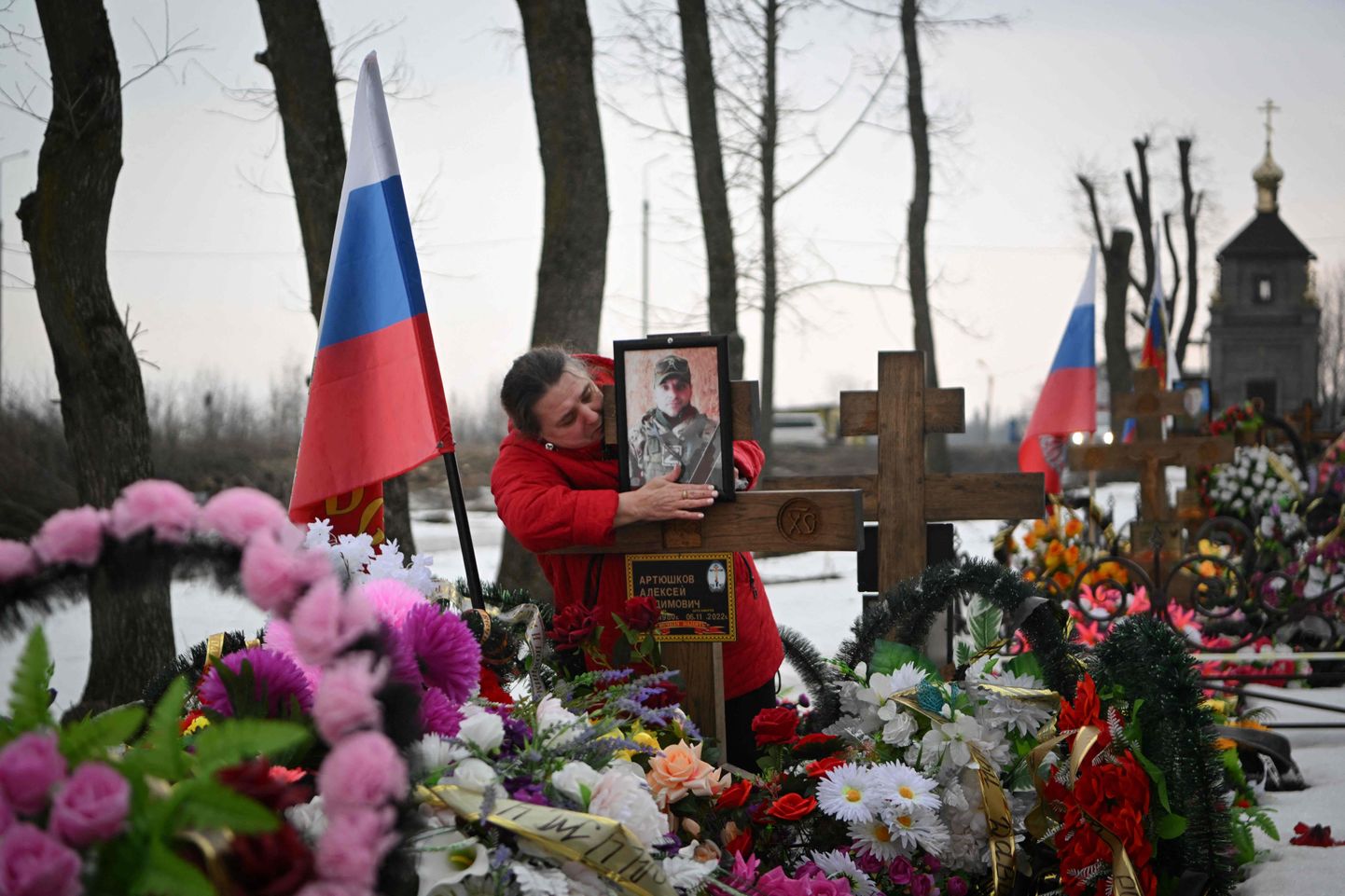 Женщина плачет у могилы погибшего российского солдата на кладбище в Тульской области.
