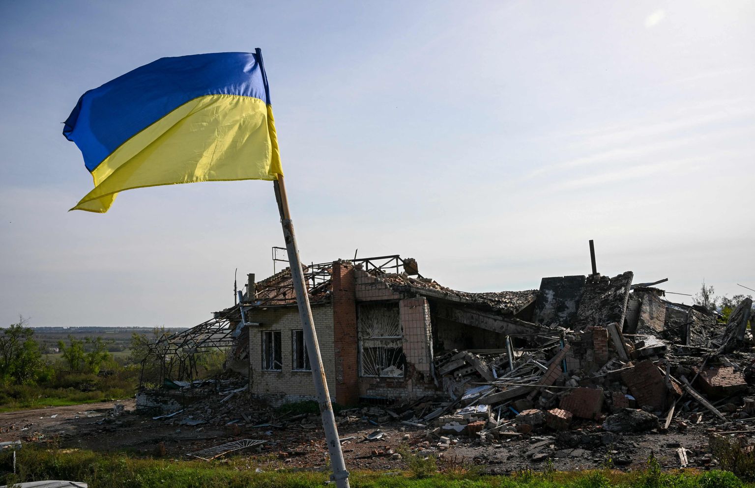 Украинский флаг у разрушенного дома в Изюме. Фото иллюстративное.