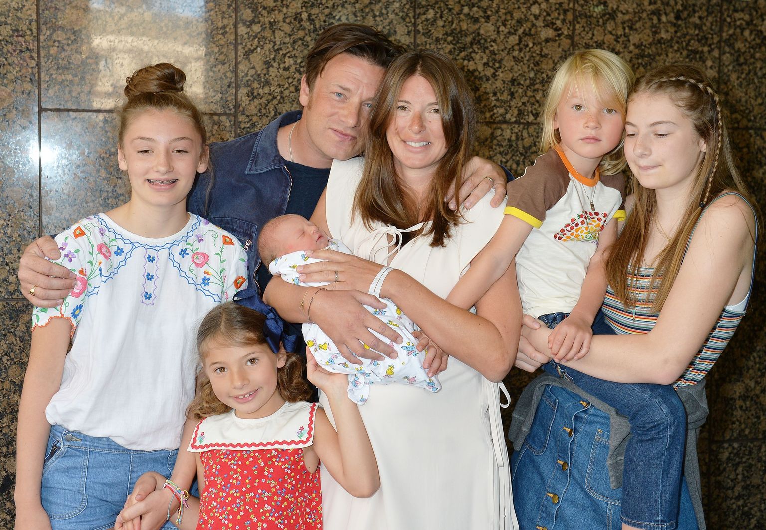 Jools ja Jamie Oliver poseerivad haigla ees 2016. aastal pärast poeg Riveri sündi. Pildil on ka teised lapsed, vasakult Daisy Boo Pamela, Petal Blossom Rainbow, Buddy Bear Maurice ja Poppy Honey Rosie.