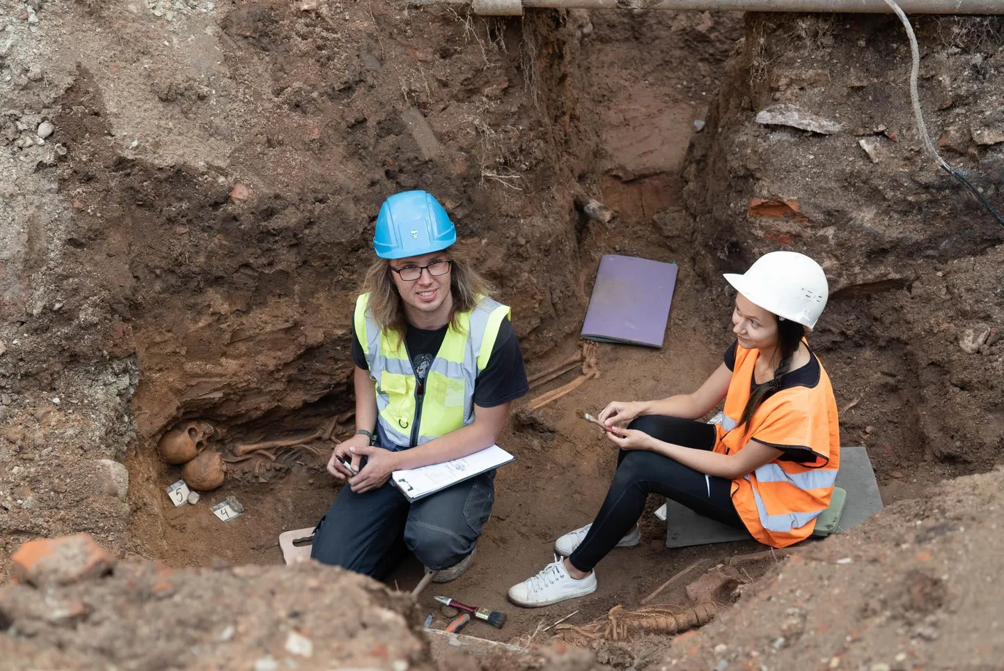 Arheoloogid Martin Malve ja Linda Vilumets kaevavad välja kõik torustike alla jäävad skeletid. Teisipäevase seisuga oli neid 11.