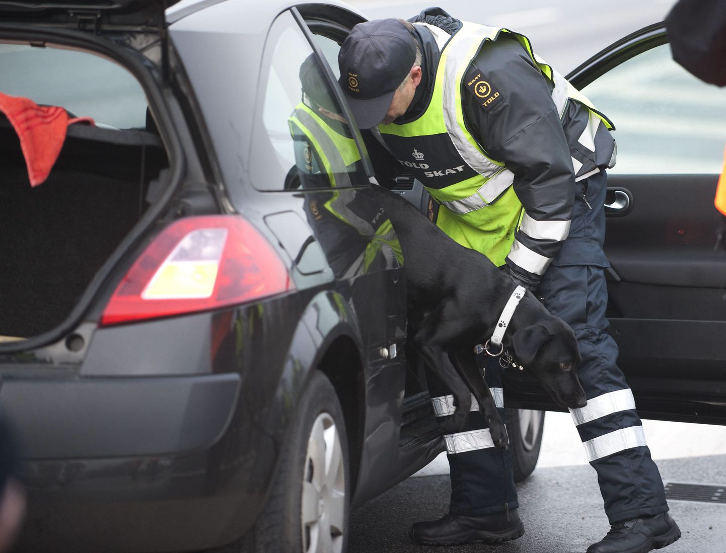 Taani politseinik kontrollib autot.