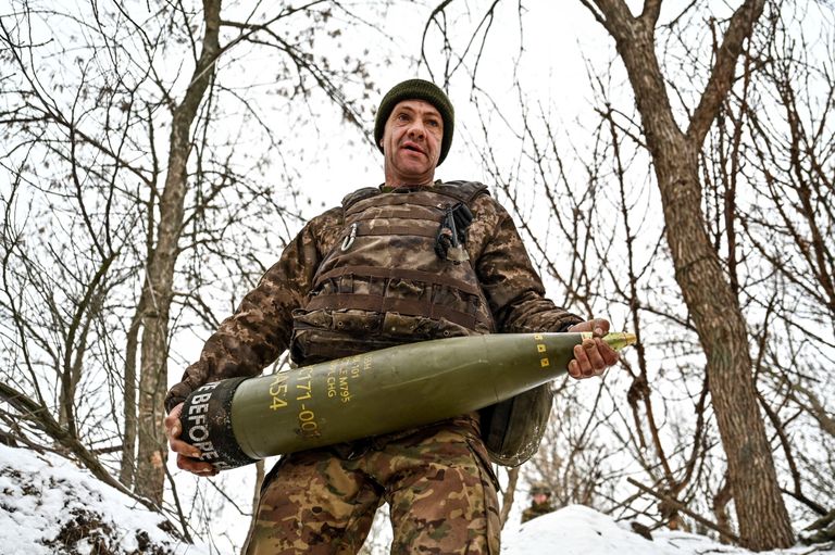 Украинский солдат с артиллерийским снарядом.