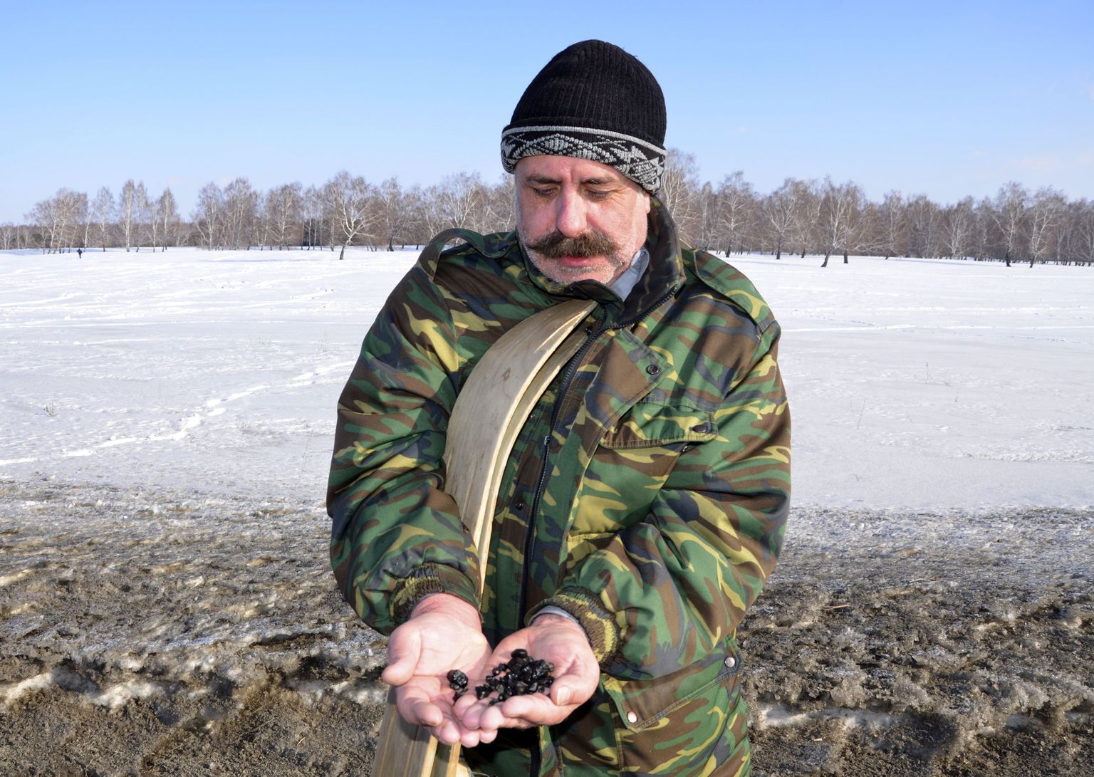 Kohalik elanik näitamas Tšeljabinski lähedal alla kukkunud meteoriidi arvatavaid tükke.