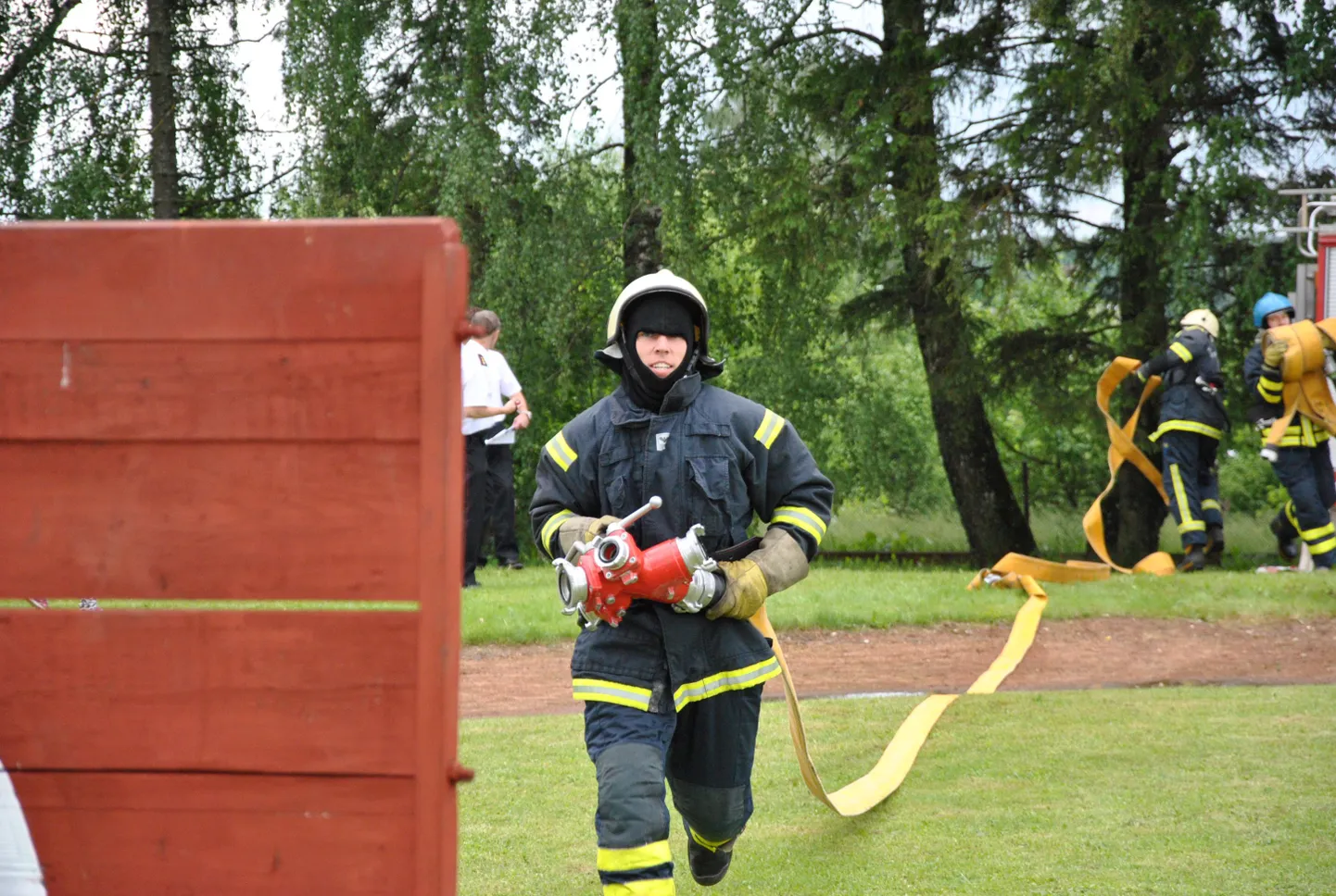 Alor Kasepõld võistlusel, jagaja süles, voolikuliini laiali vedamas.