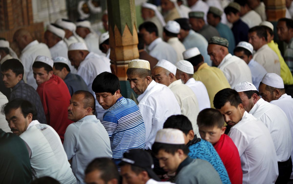 Этнические уйгурские мужчины молятся в мечети во время Рамадана в городе Кашгар, провинция Синьцзян
