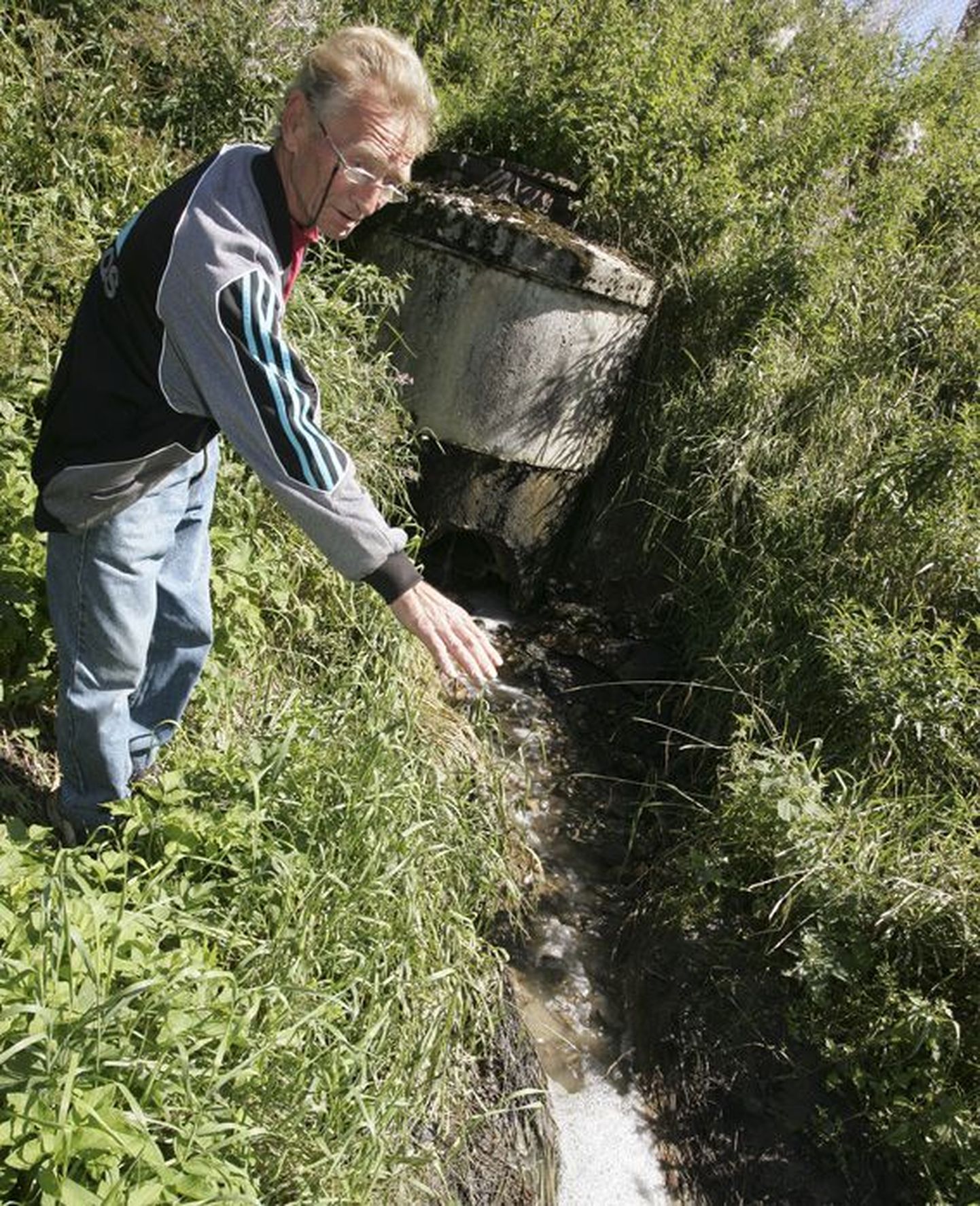 Vao küla elanik Jüri Elmend näitab Väike-Maarja biopuhastist väljuvat vett, mille kobrutav vaht ja hägusus annavad tunnistust, et puhastusseadmed töötavad suvesoojuses ebaefektiivselt.