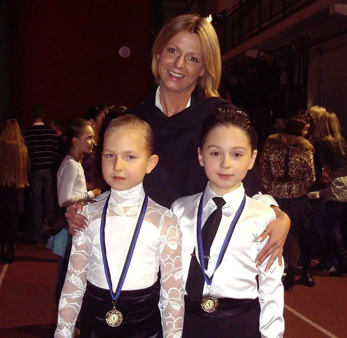 Eliisa Abramova ja Artjom Garbunov treener Olga Kosminaga pärast võistlust.