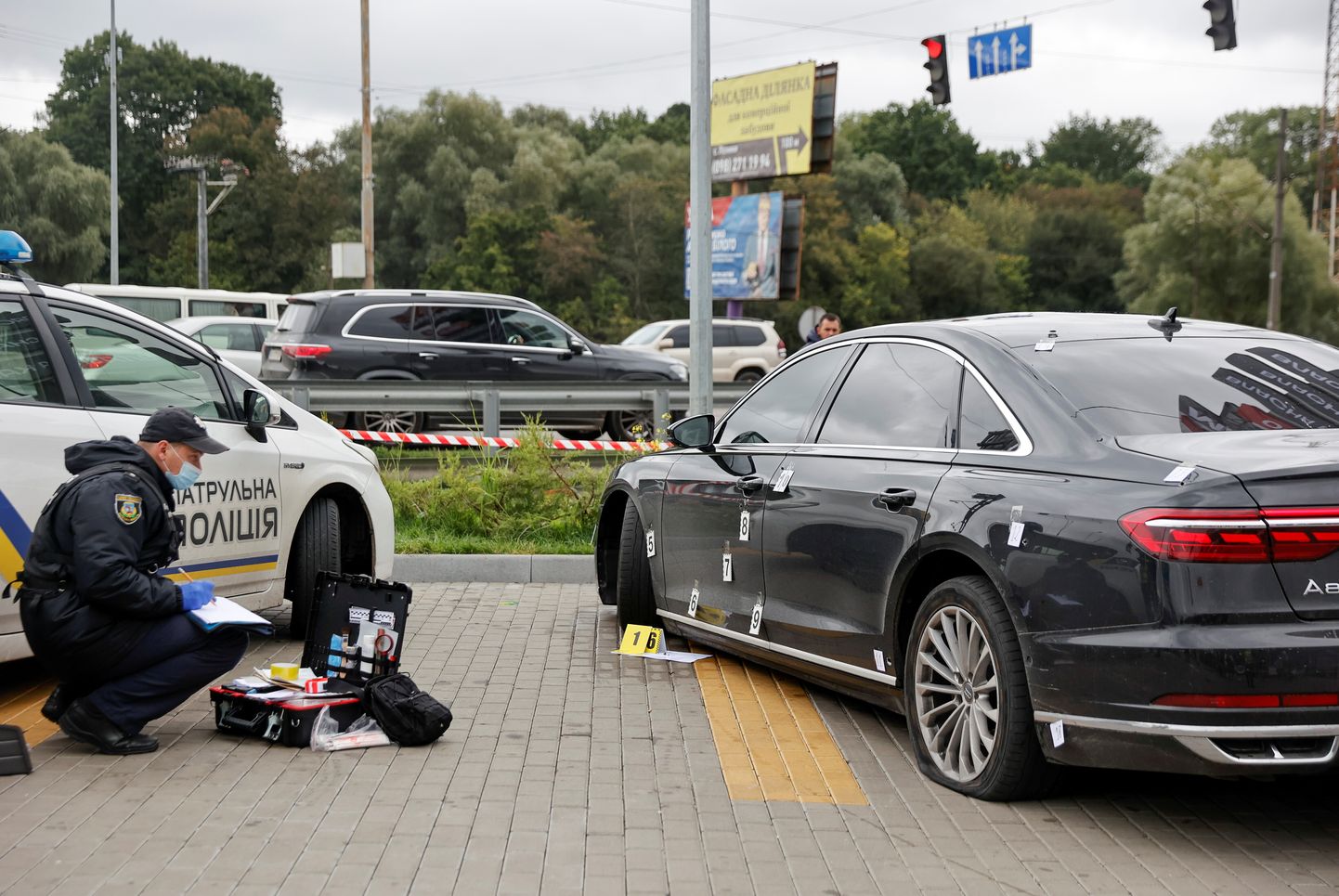 Полицейские изучают подвернувшийся обстрелу автомобиль Сергея Шерифа.