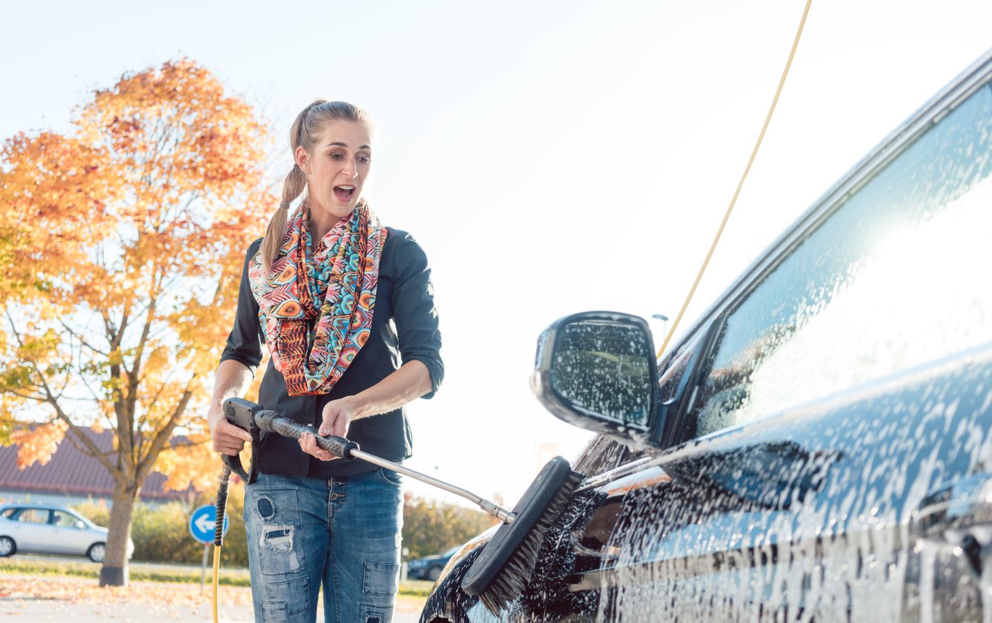 Woman cleaning her vehicle in self-service car wash