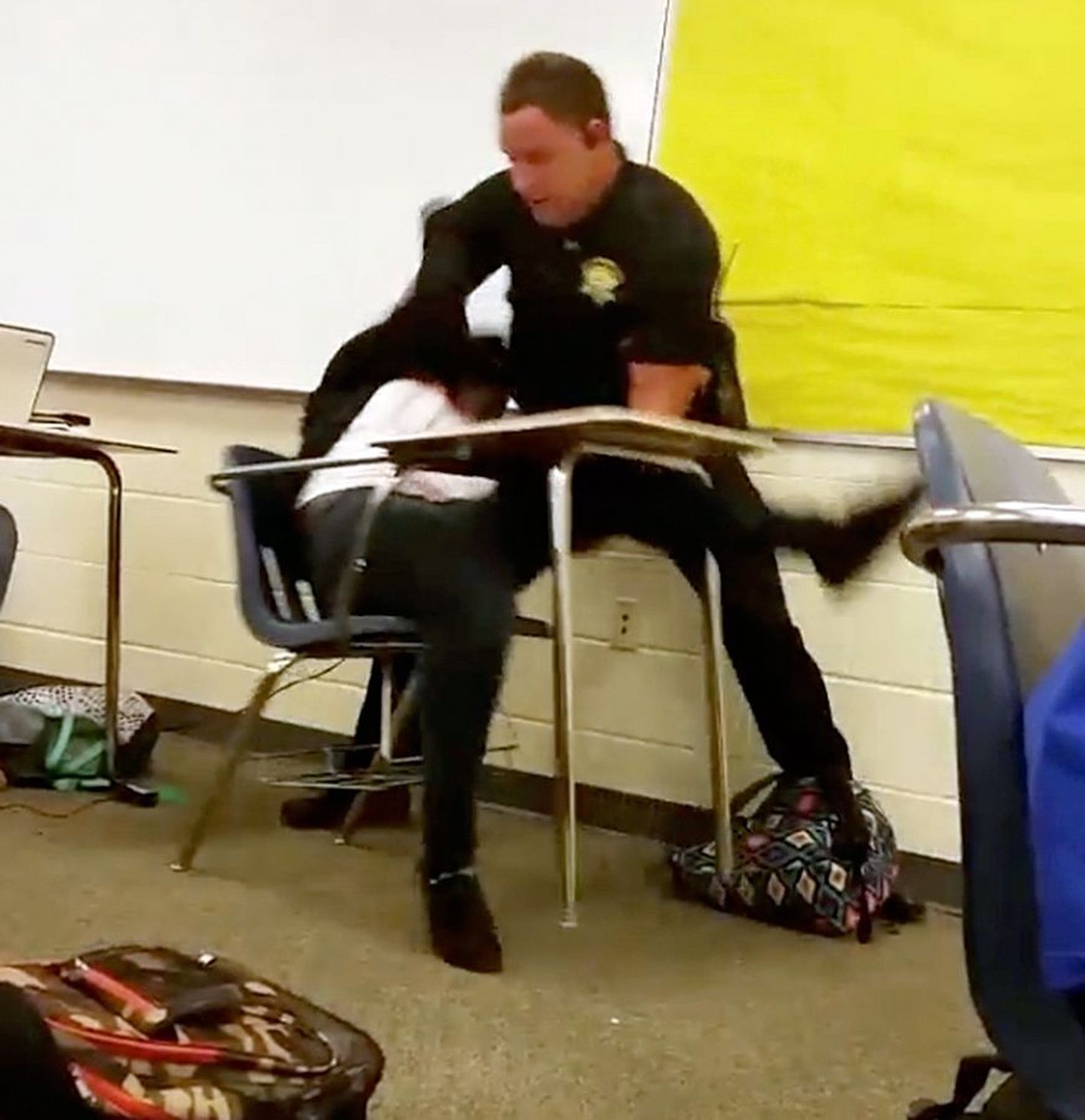 Полицейский Бен Филдс применяет силу к школьнице.