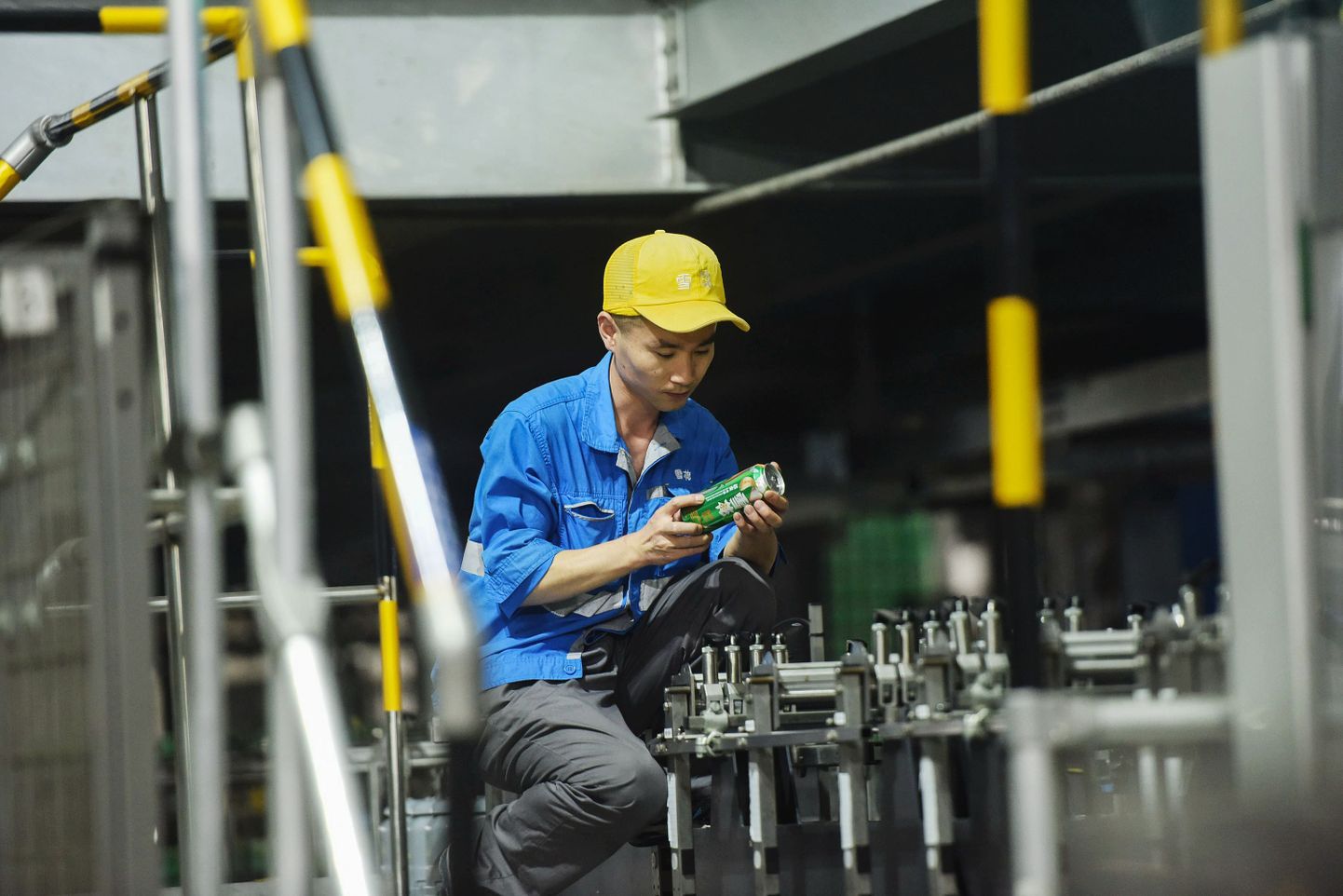 Hiina õlletehase töötaja kontrollib õllepurkidele trükitud teksti õigsust.