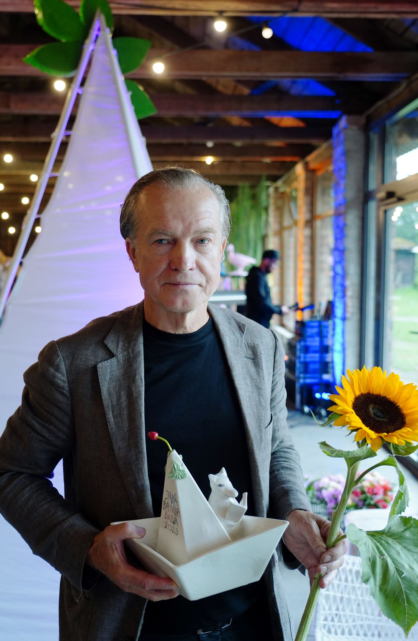 Jāņa Baltvilka balvas rakstniecībā laureāts dzejnieks Žebers ar saņemto balvu par dzejoļu krājumu "Ejas un asakas" apbalvošanas ceremonijas laikā Latvijas Universitātes Botāniskajā dārzā.