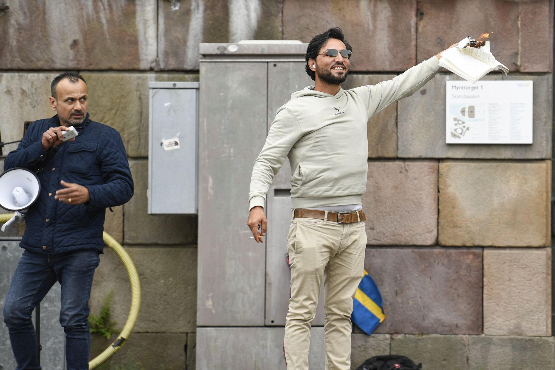 Vīrietis ar degošu Korānu rokās protesta akcijas laikā Stokholmā, Zviedrijā, 2023. gada 31. jūlijā.