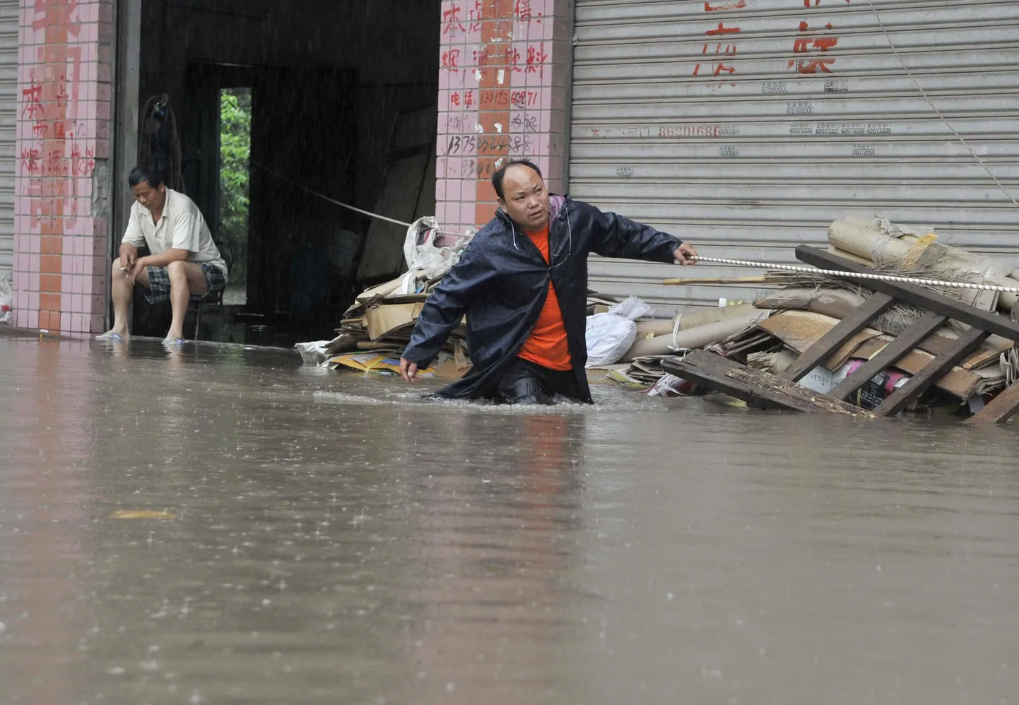 Kohalik elanik üleujutatud tänaval eile Chongqingi linnas Hiina edelaosas.