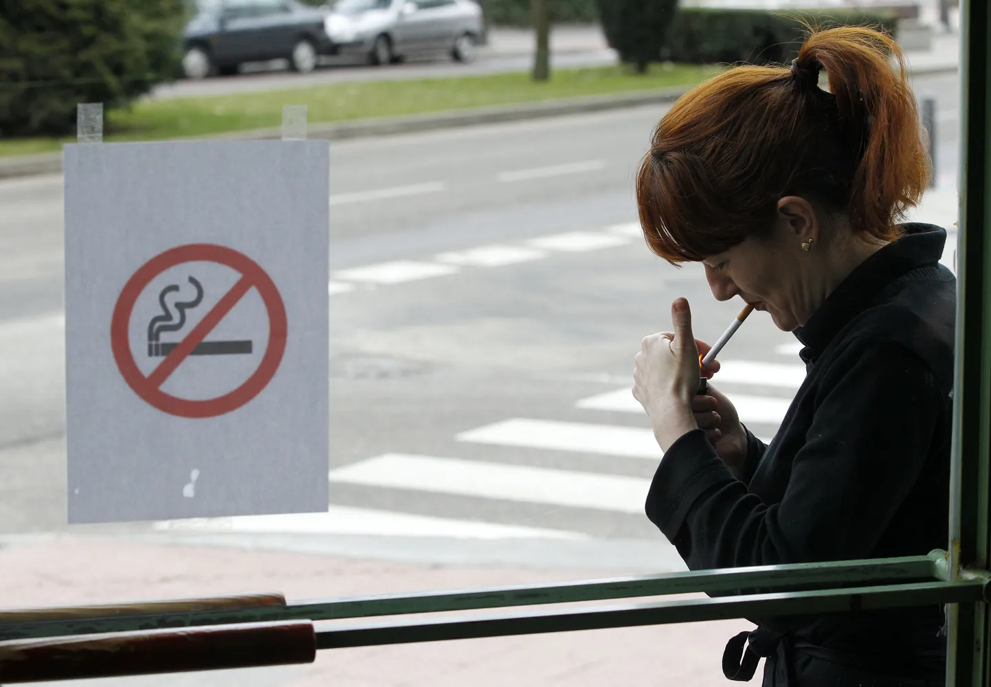 Naine süütab sigareti Burgoses ühe kohviku ees.