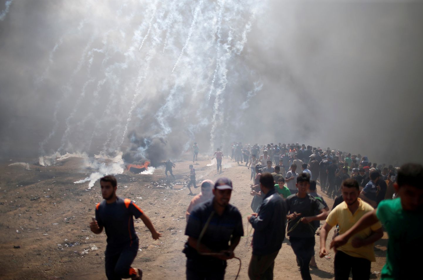 Palestiina meeleavaldajad Iisraeli piiril pisargaasi eest põgenemas.