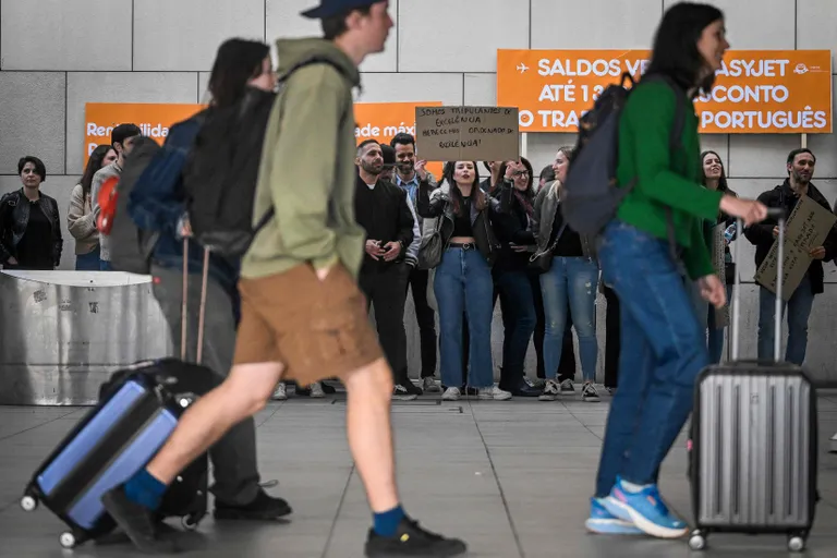 Работники португальского бранча компании easyJet протестуют против плохих условий труда вдоль стены терминала в аэропорту Лиссабона, 2023.